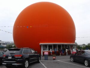 Kiosque orange géant avec clients au Canada.