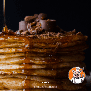 Stack of pancakes with syrup and chocolate.