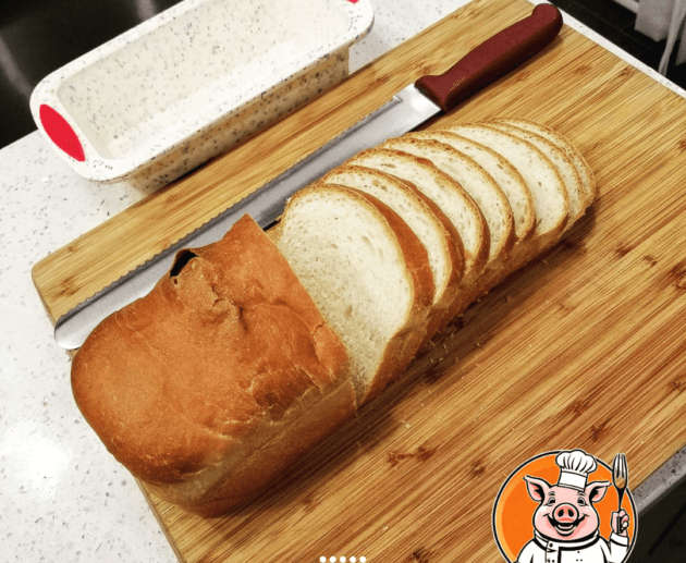 Sliced bread on cutting board with knife.