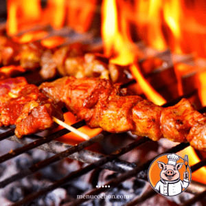 Pork skewers grilled over an open flame.